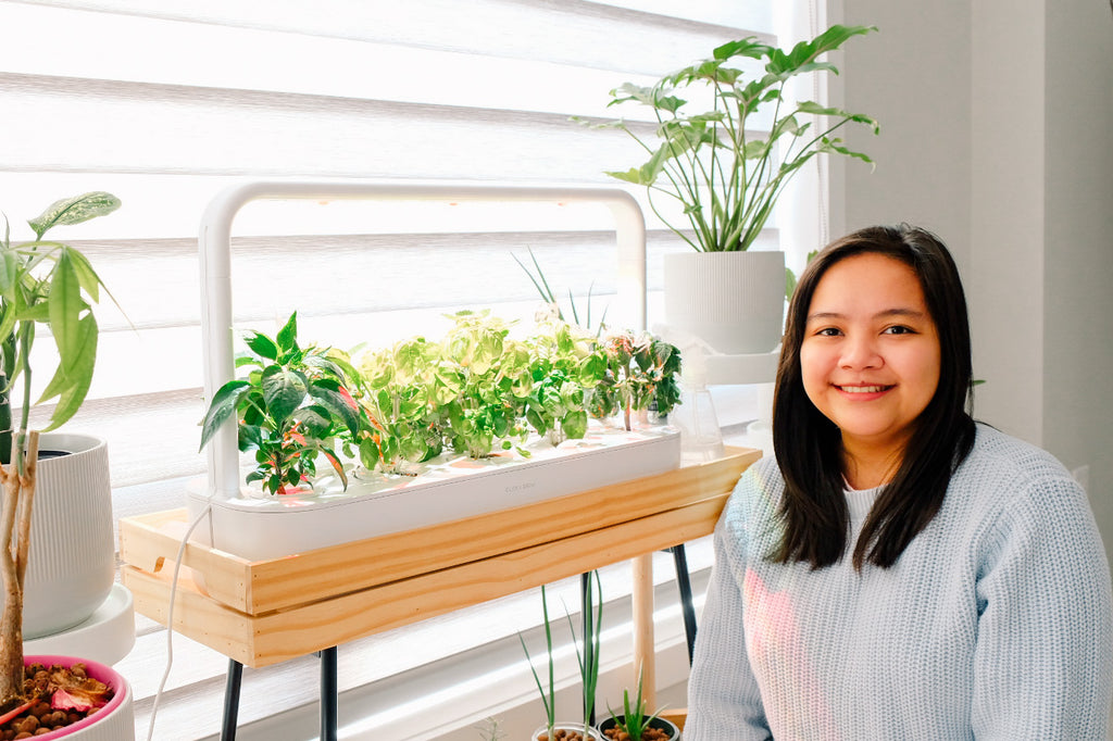 Indoor gardener posing with the Smart Garden 9 in her home.