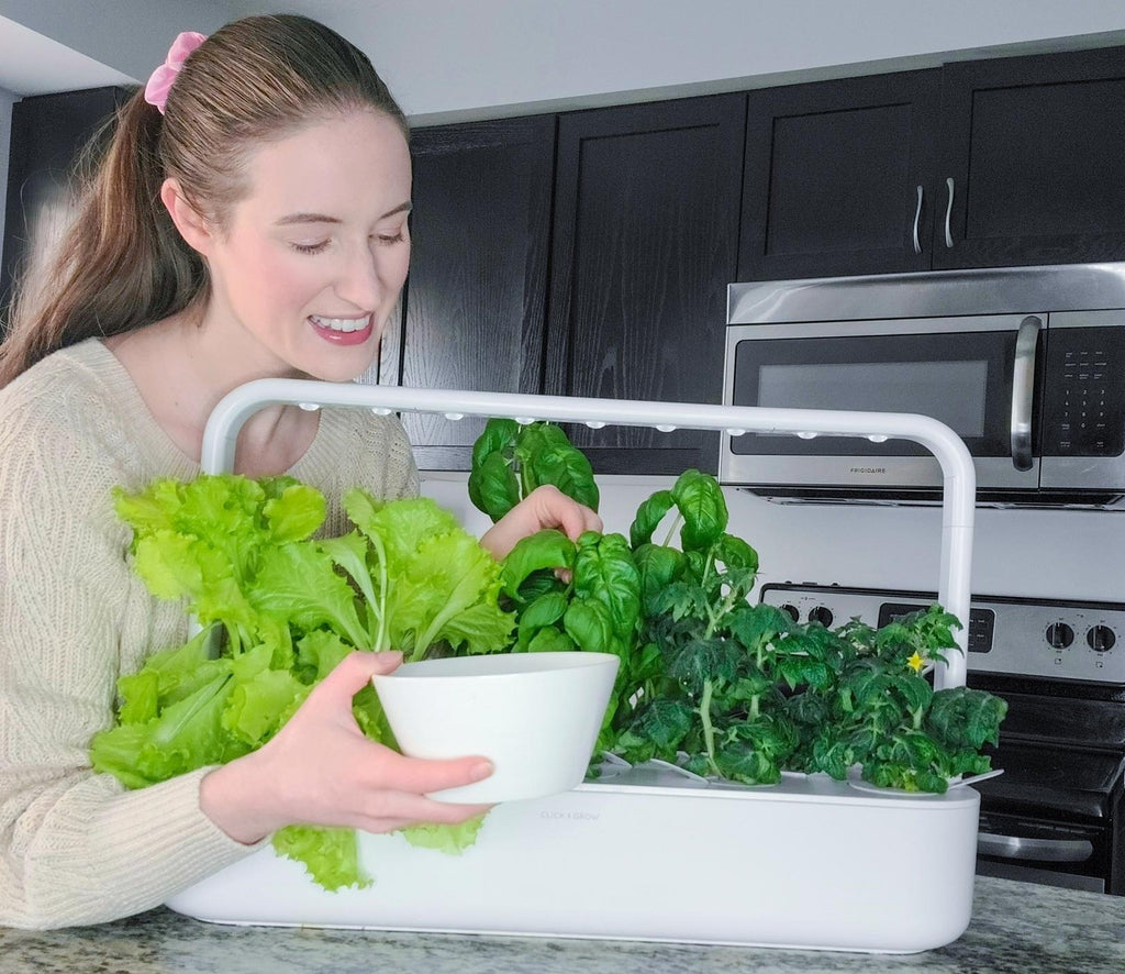 Woman harvesting greens from the Click and Grow Smart Garden 9.