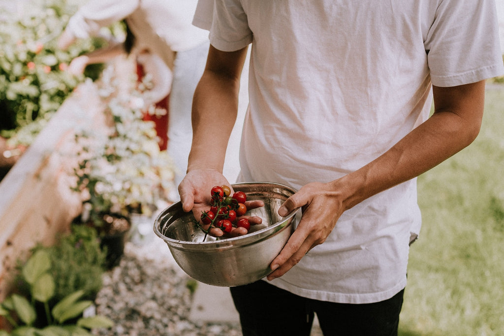 Man holding fresh produce in a bowl.