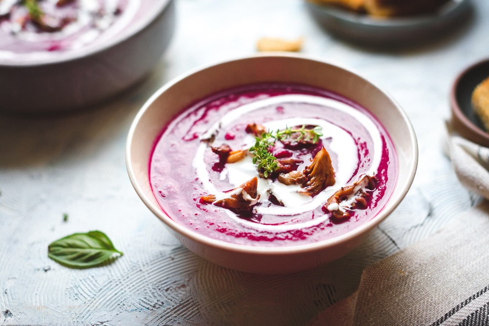 Purple colored soup in a bowl.