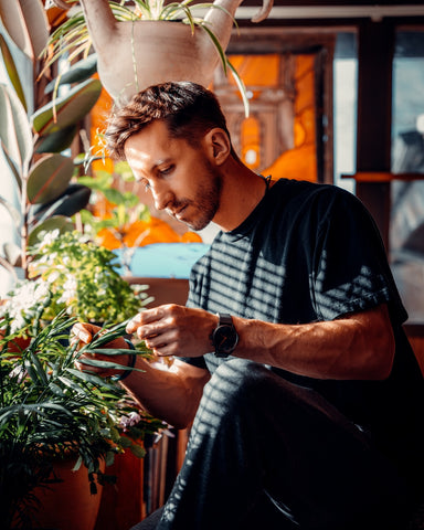 Indoor gardener tending to houseplants.