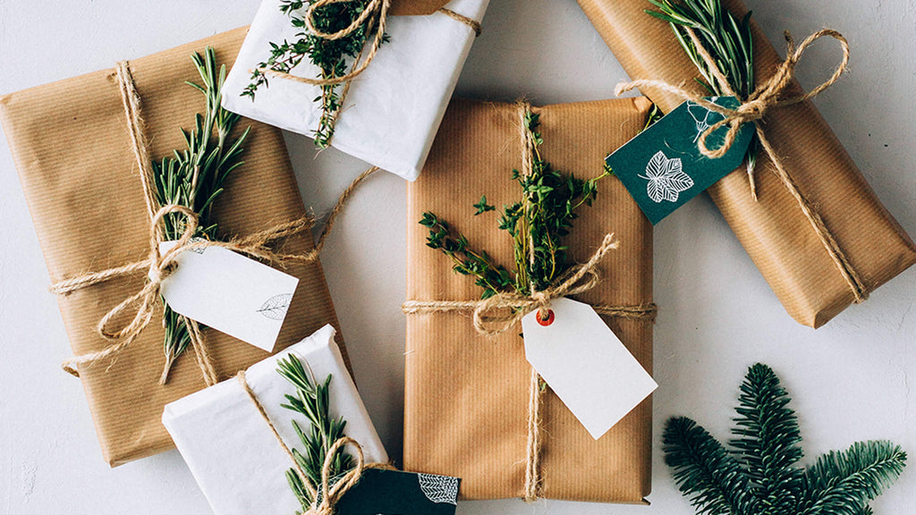 Presents that have been wrapped and decorated using brown paper, string and herbs.