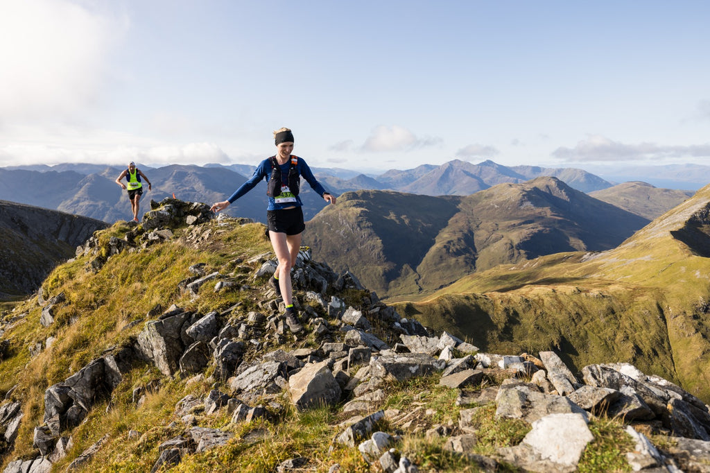 A female mountain runner heads over rough terrain during Skyline Scotland trail running weekend.
