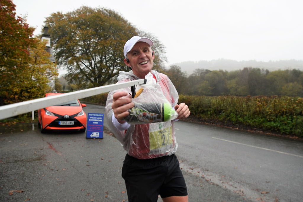 A runner collects nutrition supplies from feed station during the Brathay 10in10