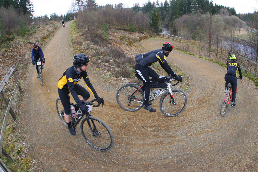 Several gravel riders take on a corner on a dry trail