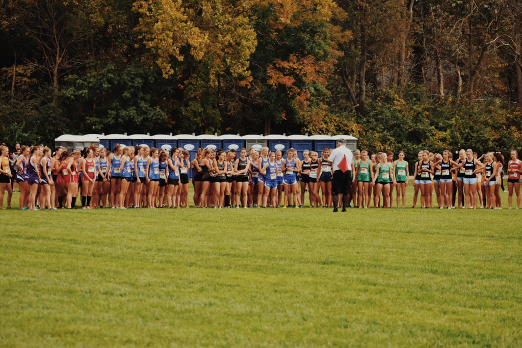 Female cross country runners stood on the starting line before an xc race