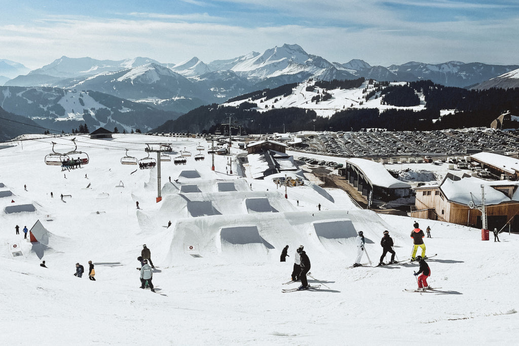 Skiers enjoy jumps in the freestyle area of a ski resort