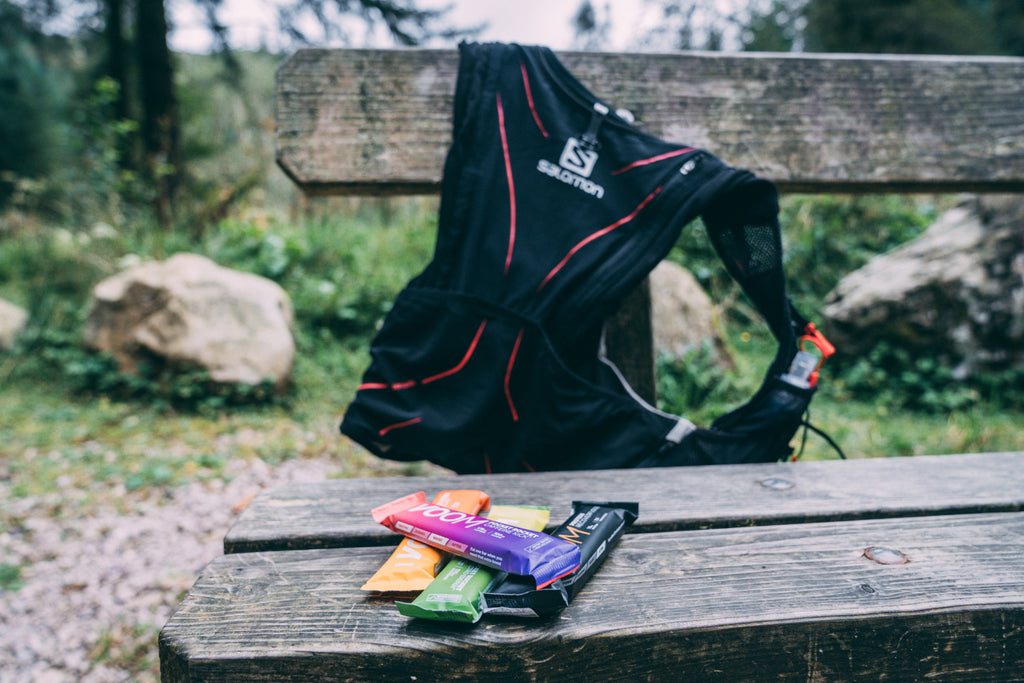 Some energy bars on a bench beside a running pack