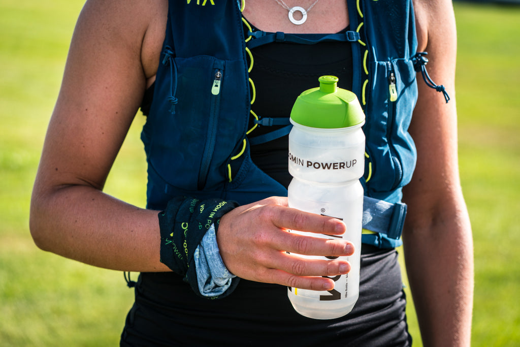 A runner holding a VOOM water bottle to maintain hydration whilst training