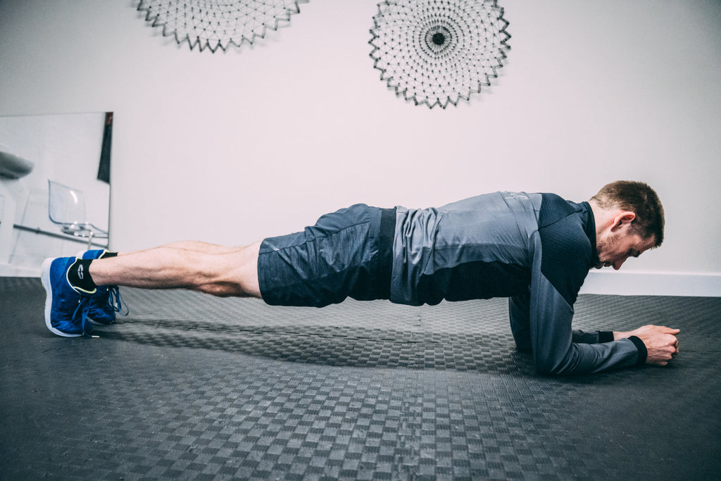 A runner doing strength training holding a plank position