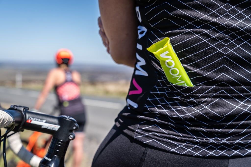 A VOOM Pocket Rocket Electro Energy bar protruding from the rear pocket or a cycling jersey