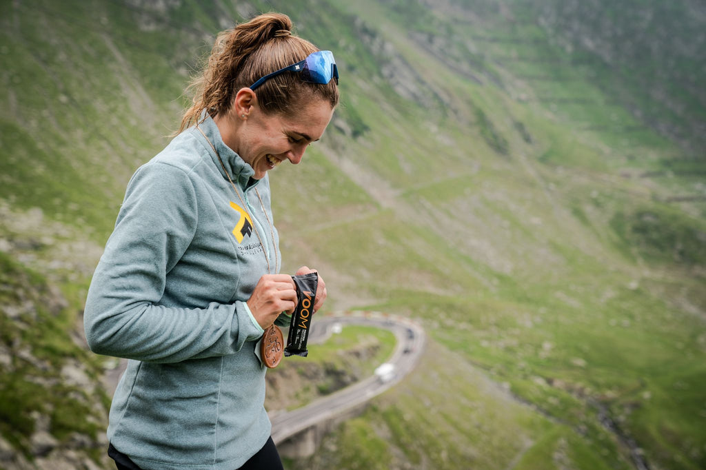 A female runner opens a protein bar after a workout