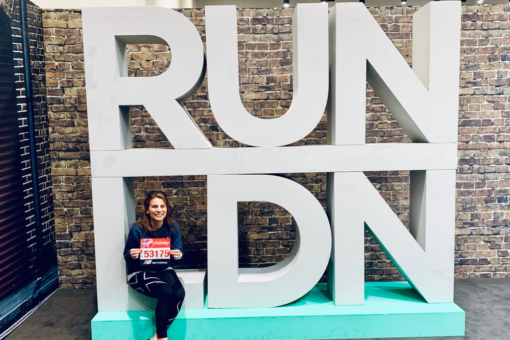 Ruth Bennett, marathon runner, poses in front of a 'RUN LDN' sign after registering for the event