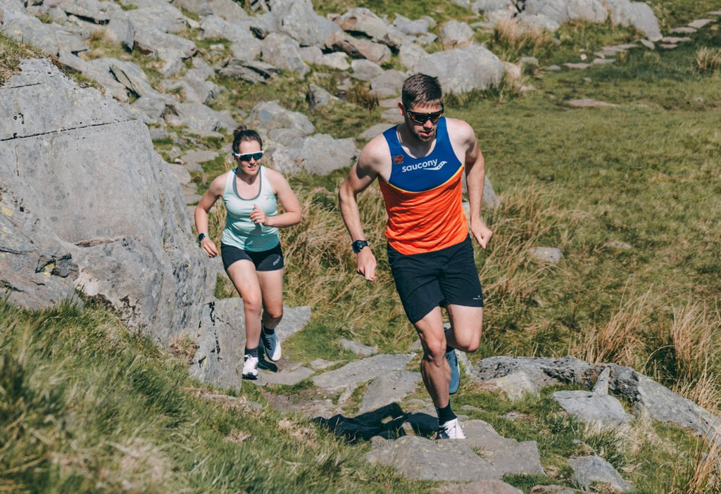 Two runners, running uphill in Lake District
