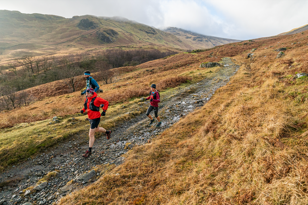 3 Runners enjoy trial running in a remote lake district valley