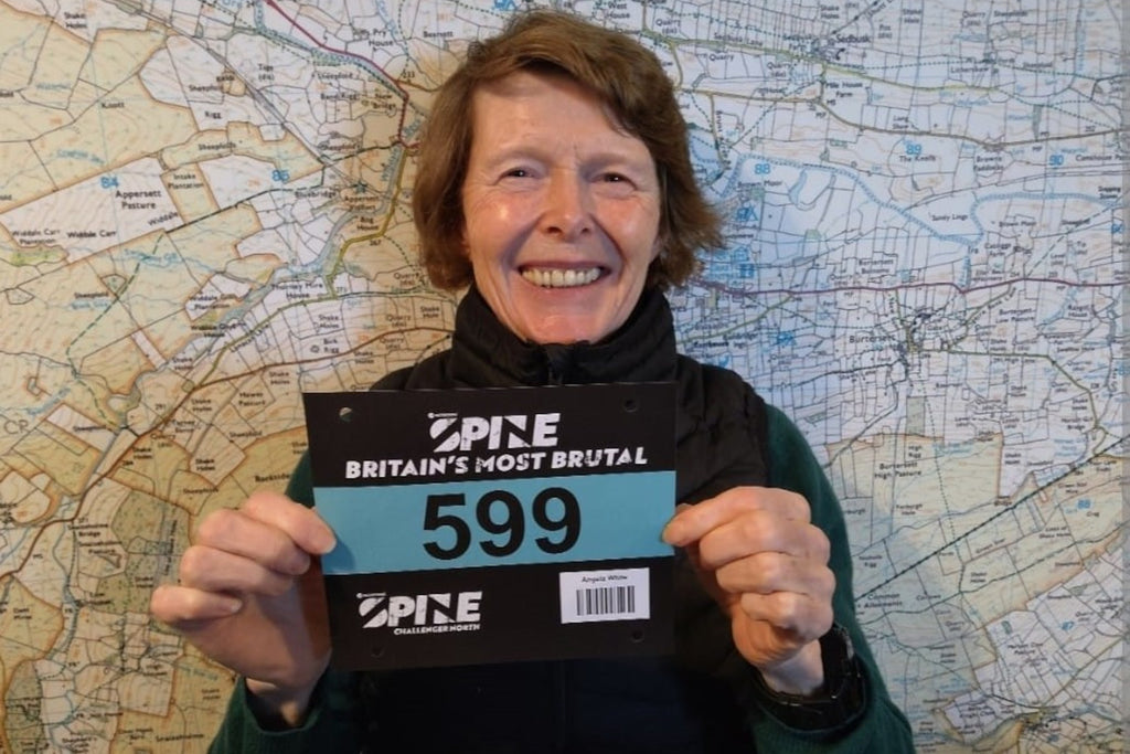 Ultra runner Angela White proudly holds her starting number at the registration of The Spine Race 2024