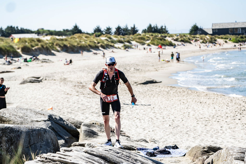 A runner battles over rocks and sand on the Norweigan coastline during the thorXtri extreme triathlon event