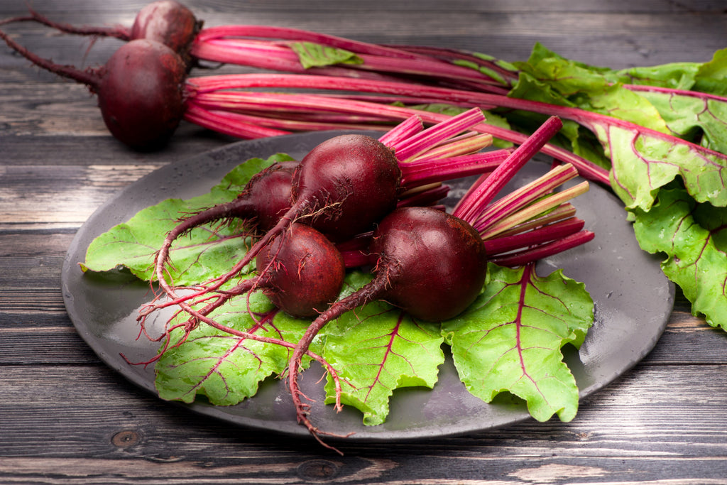 A small bunch of washed beetroots on a plate ready to be cooked