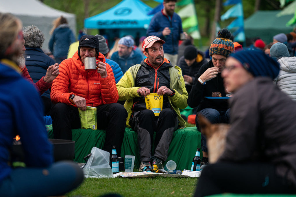 Ultra runners eat an evening meal in camp during a multi day running race