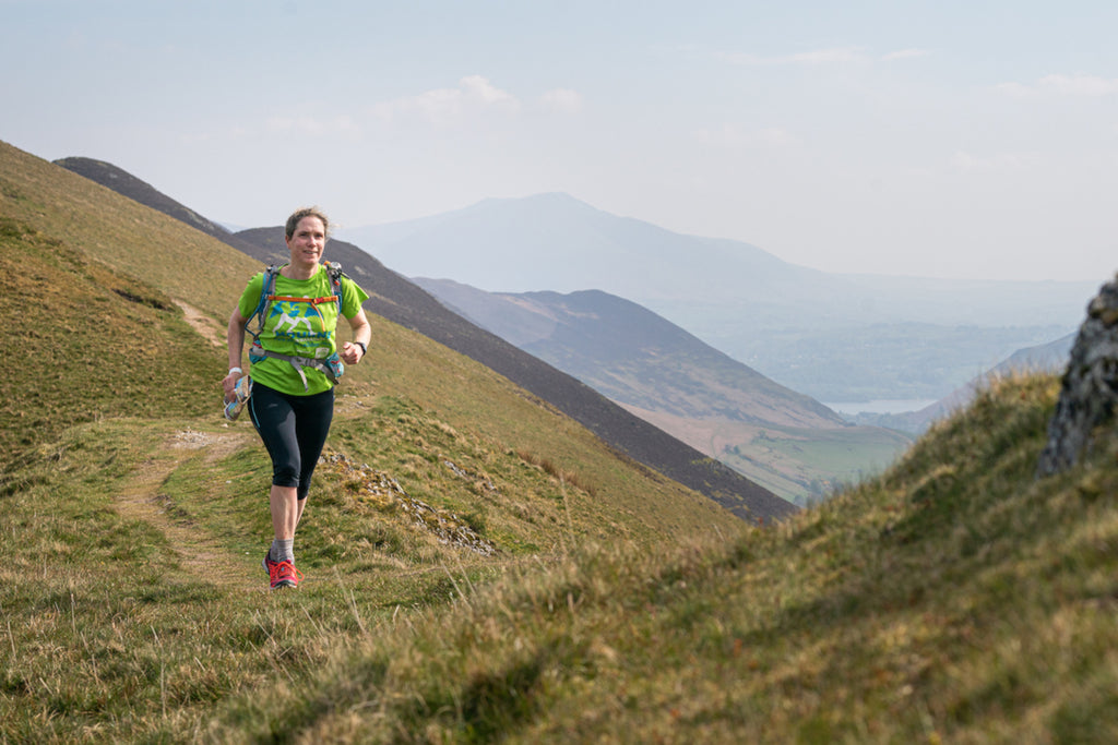 Female runner in the lakeland fells on a clear day