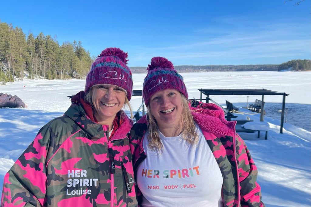 Two Ice swimmers wearing warm cloths and bobble hats after a winter swim in Finland.