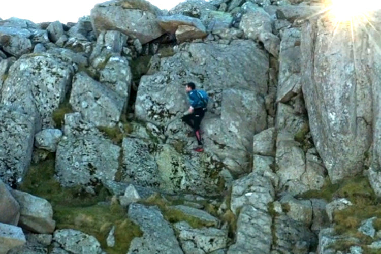 A man traversing a rocky scramble in Snowdonia during Russell Bentley's Paddy Buckley Round