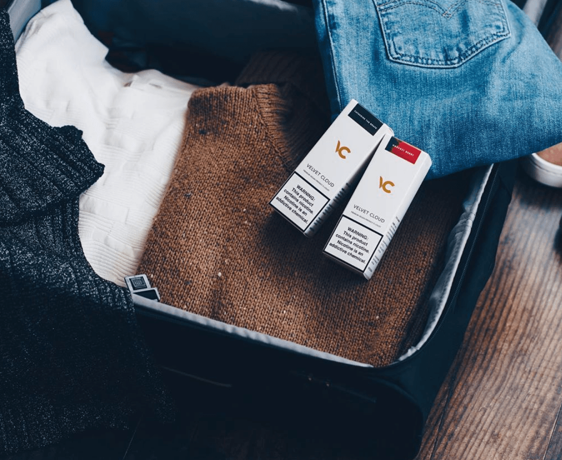 valise préparée pour un voyage d'affaires ou des vacances avec des e-liquides pour vapoter