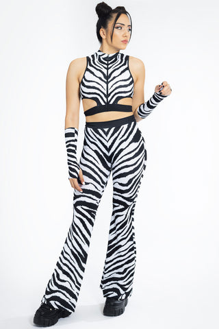 sexy woman wearing a black and white zebra print set of disco pants and cut out front zip crop top