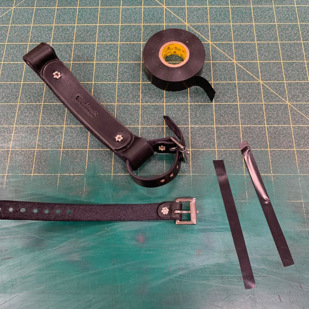 Cutting a piece of electrical tape to protect bicycle paint job from accessory rivets on Bicycle Frame Handle: one piece of tape cut lengthwise