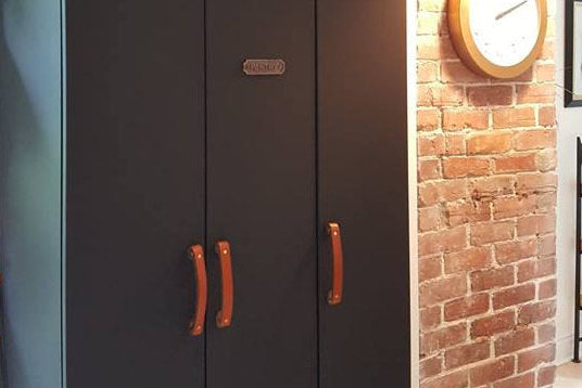 Honey Tilikum Leather Handles on Black Kitchen Cabinetry Next to Brick