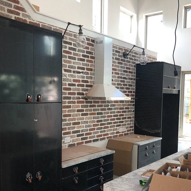 Honey Leather on Black Kitchen Cabinets with Red Brick Wall
