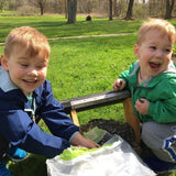 toddler boys filling bird feeder