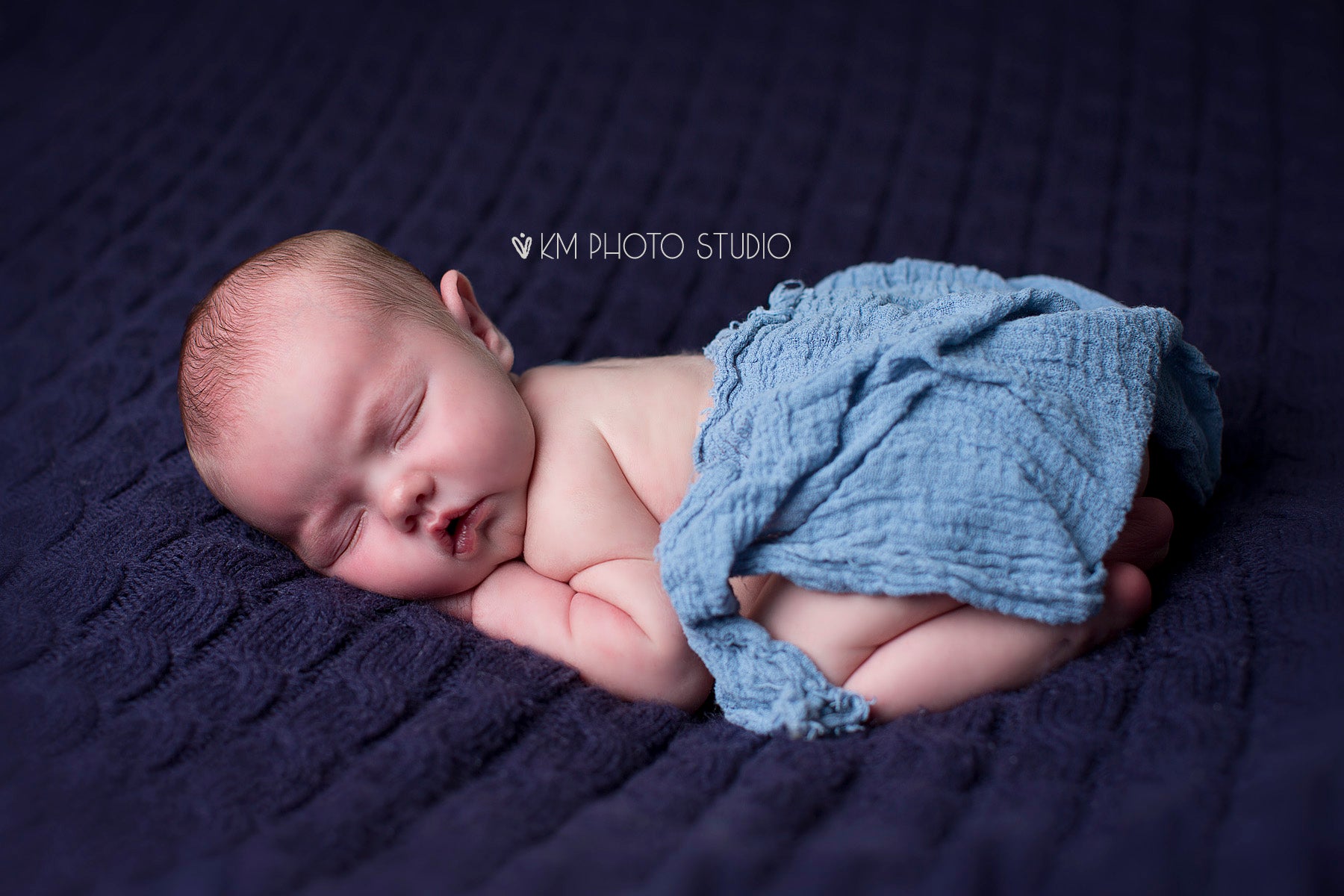 Newborn baby on napping on blue blanket