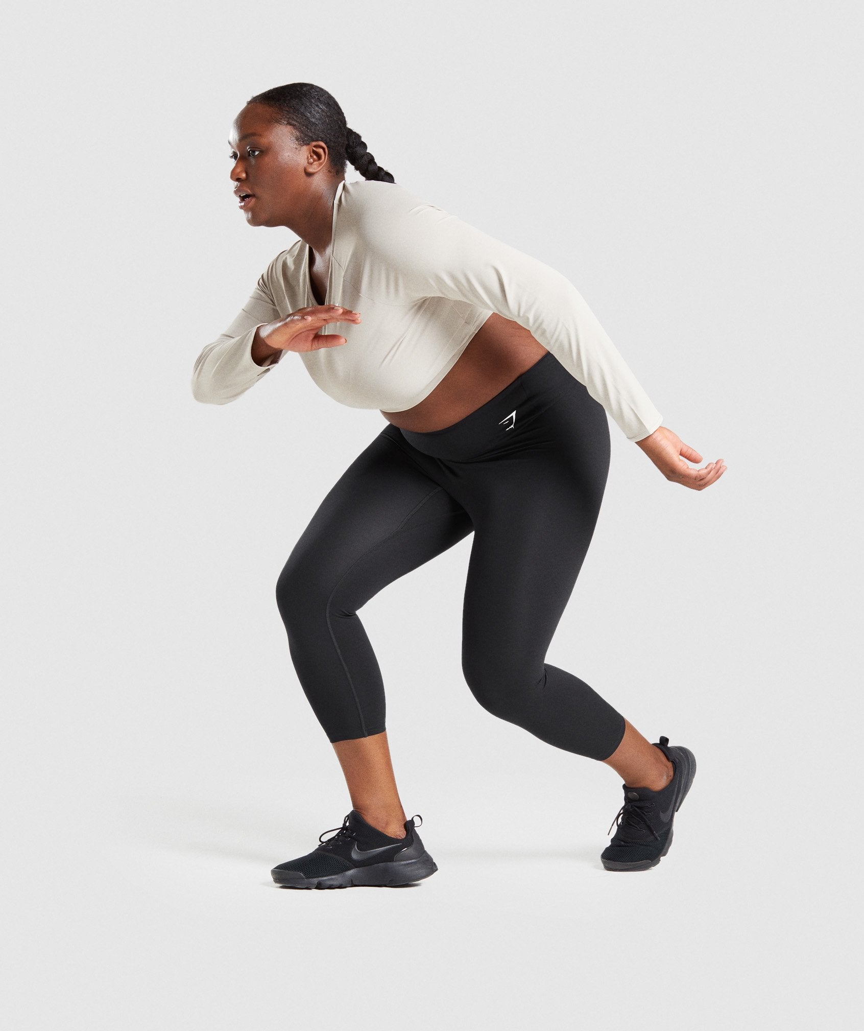 Image D1 shows model stretching wearing Training Long Sleeve Crop Top in Grey