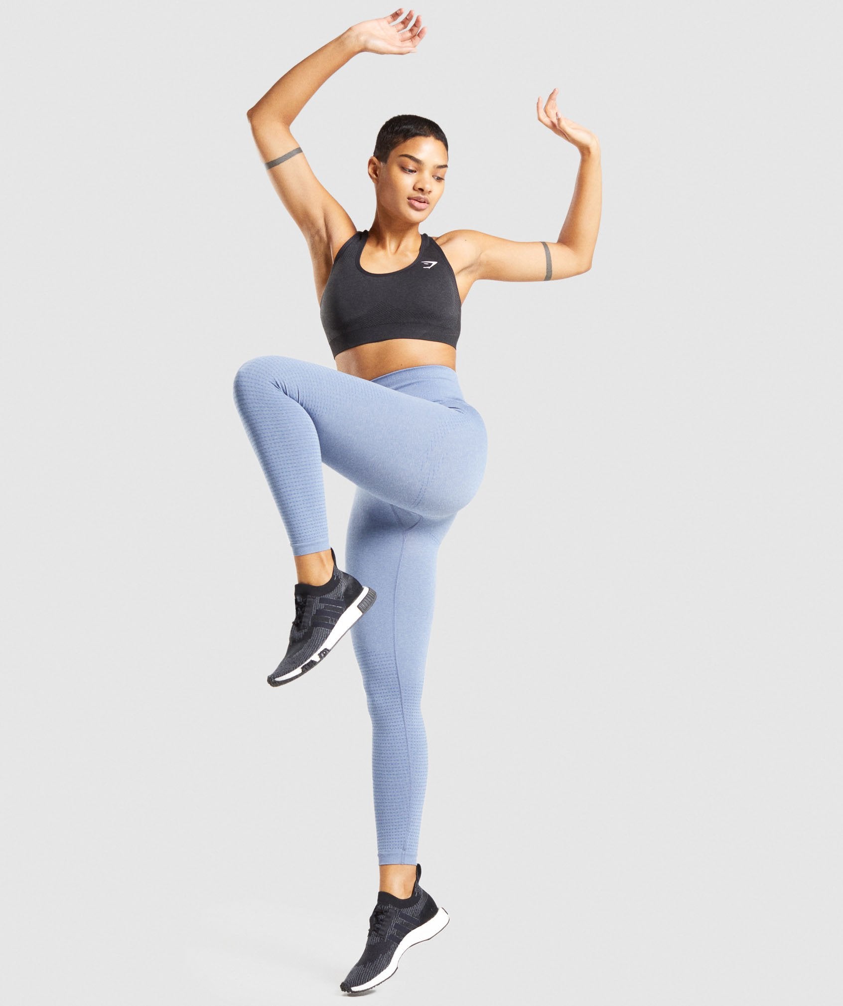 Image D shows a model jumping wearing light blue marl Vital Seamless Leggings and Sports Bra in black.