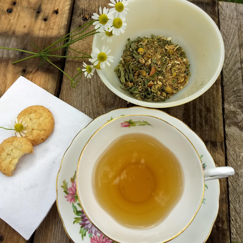 cup of tea in a floral tea cup with saucer and scones