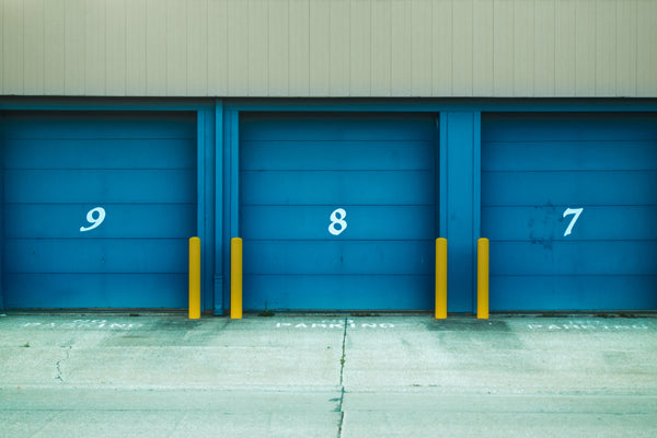 The garage-style doors of three storage units side by side