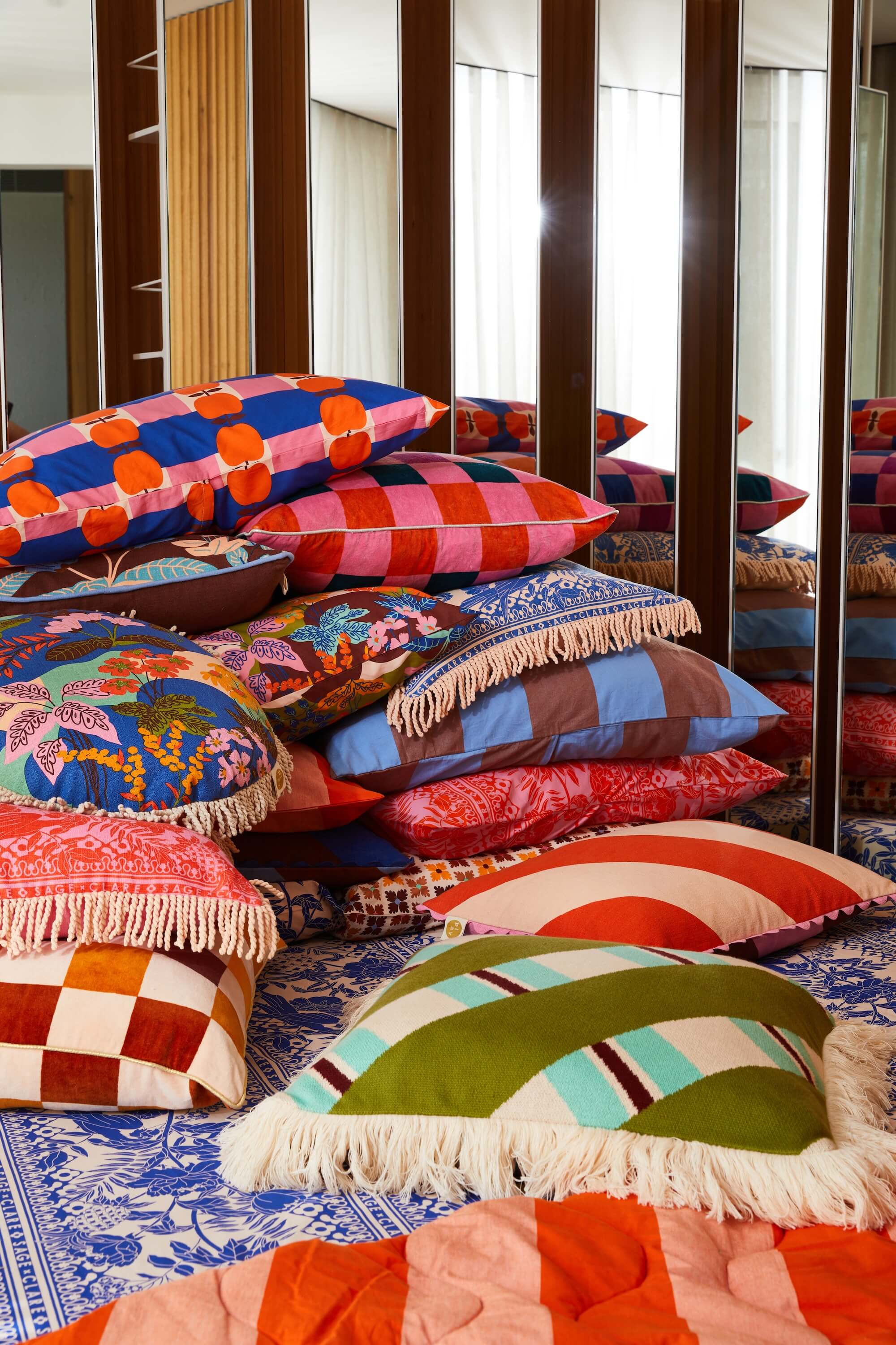 colourful boho cushions stacked in front of timber slats