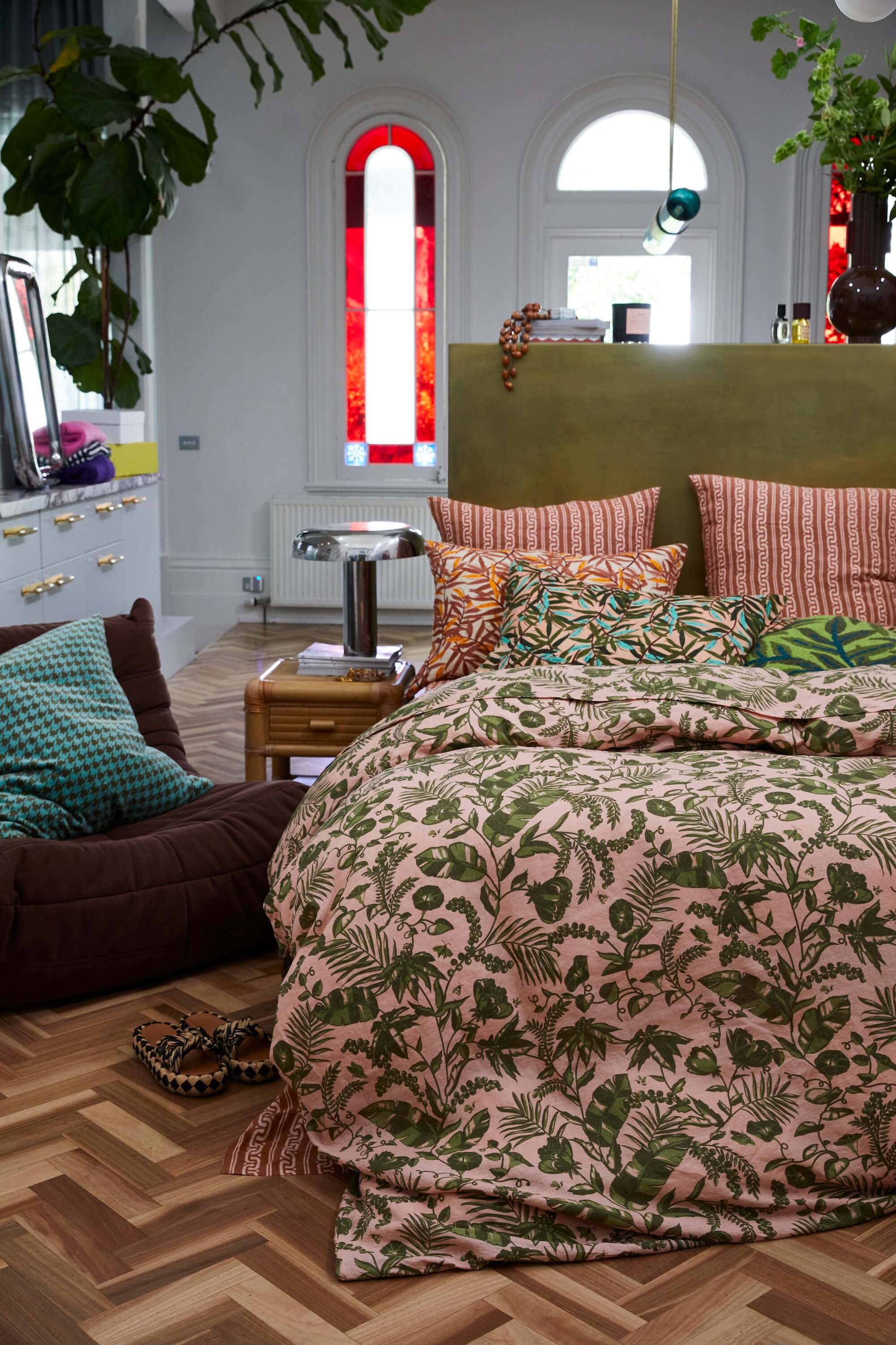 tropical leaf bed linen on timber floor with stained glass window background