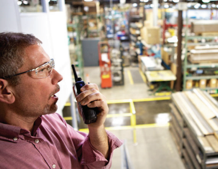 Male warehouse worker using Motorol two way radio supplied by CTS Radios Hire Service London