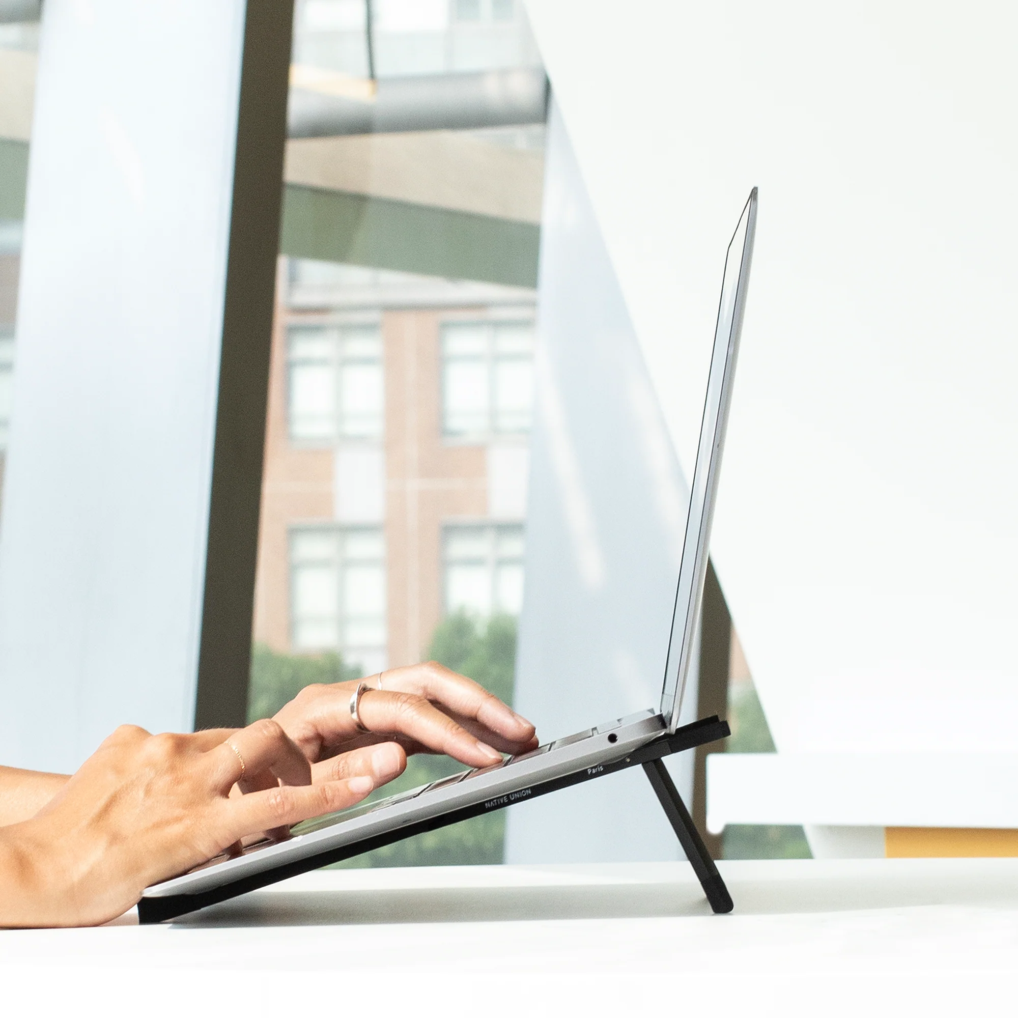 Woman holding her Native Union Fold stand with her laptop on it