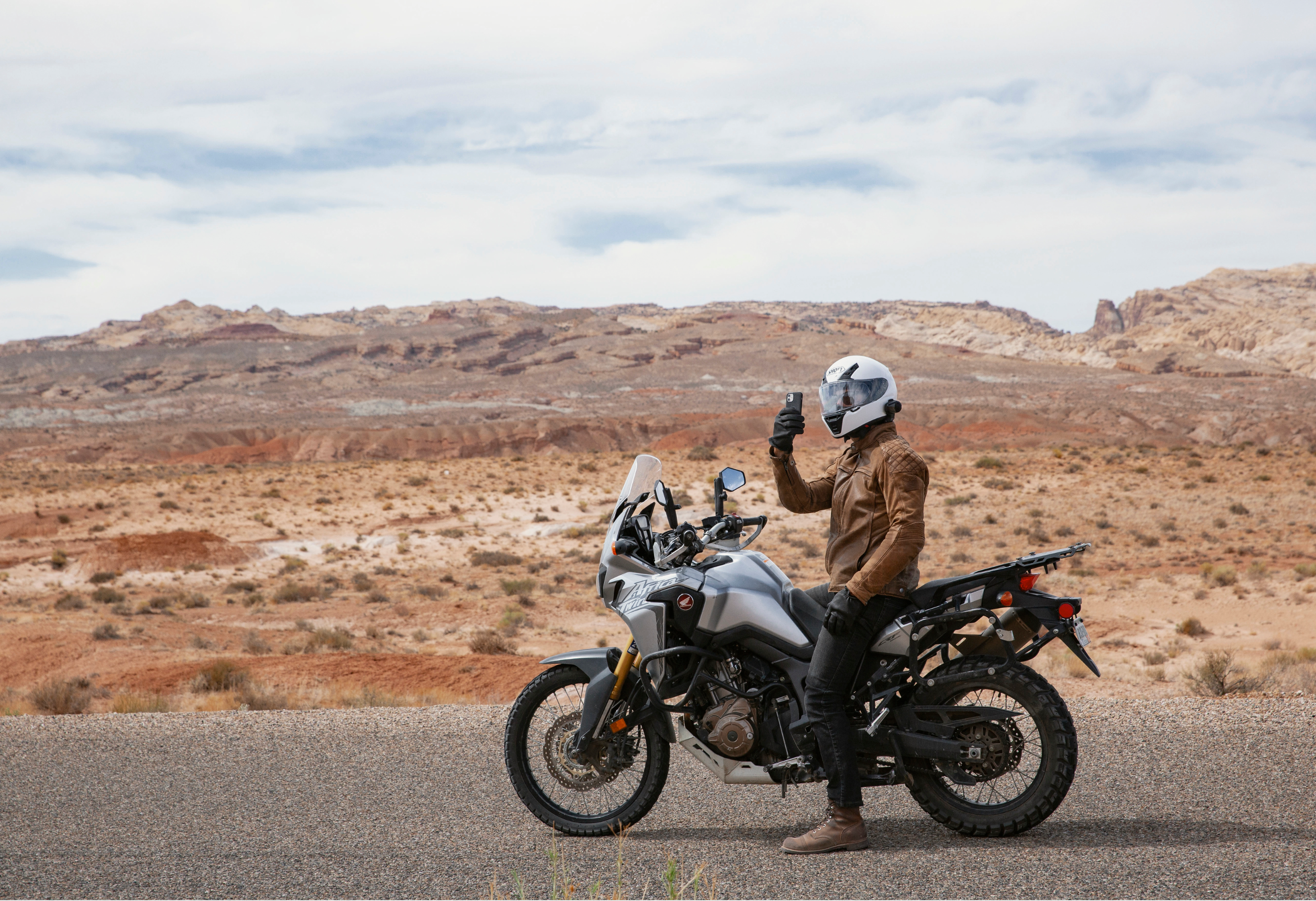 Man driving the motorcycle uses Peak Design's Moto Bar Mount in Black