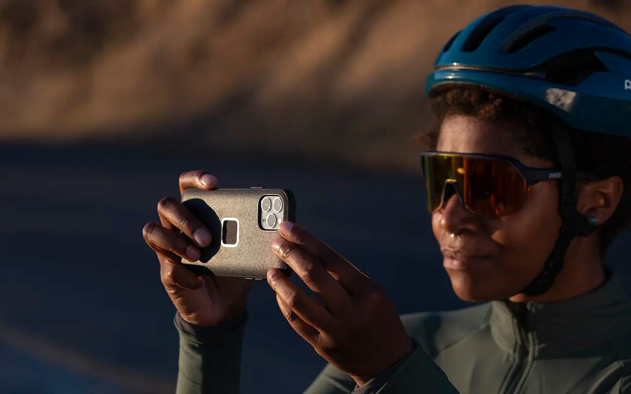 A woman captured holding her phone with Peak Design phone case