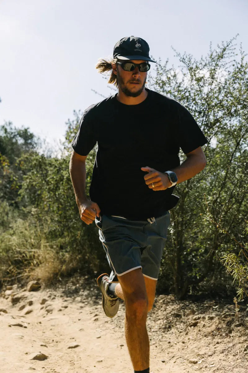 A man captured running outdoors with an Apple Watch and Nomad Band on his wrist