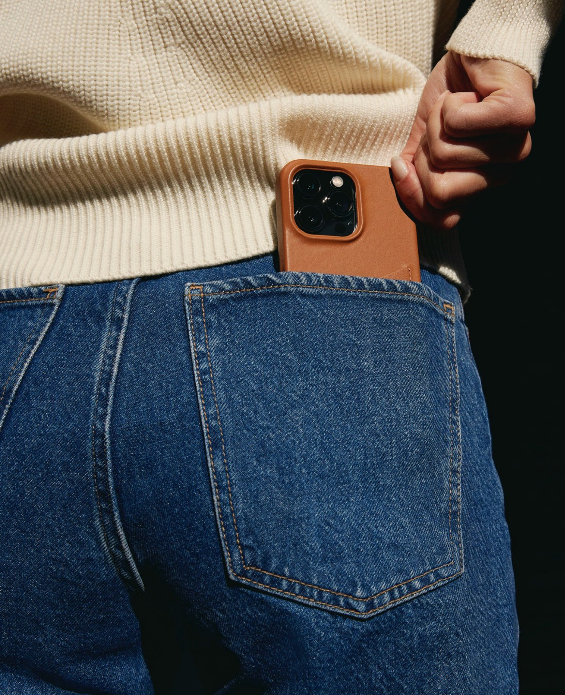 Mujjo iPhone 15 pro case in colour tan in the woman's jean's pocket