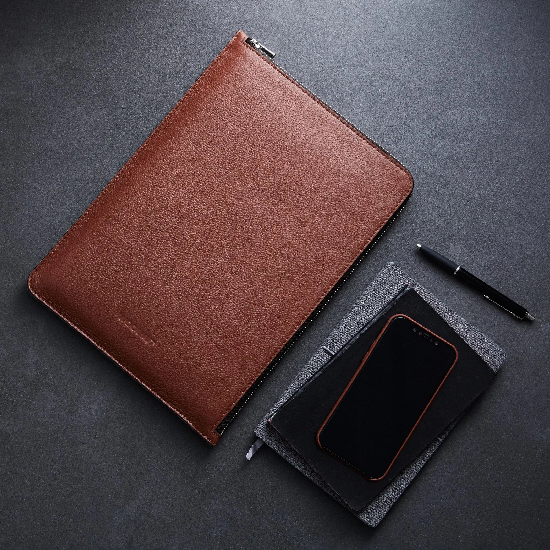 A WOOLNUT Leather Folio for 13 / 14-inch MacBook in Cognac feature with notebook, pen and pensil around