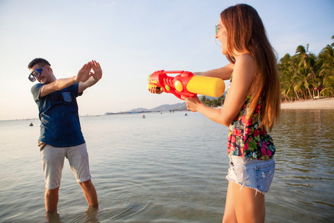 Image of a young couple playing with water guns
