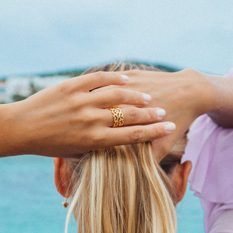 A woman's hands tying her hair into a ponytail, she is wearing the Bella Gold Ring by Agape Studio