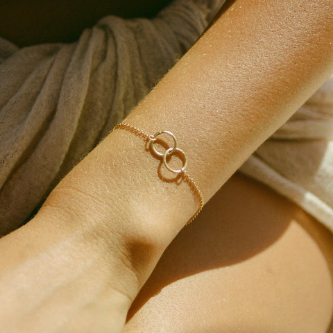 A woman's wrist wearing the Cira Gold Bracelet by Agape Studio