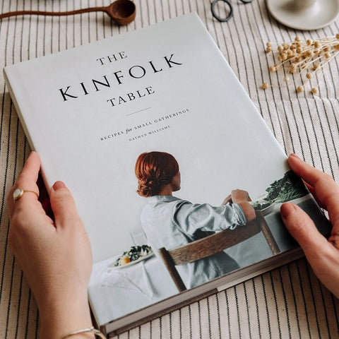 A woman's hands holding the cookbook, A Kinfolk Table: Recipes for small gatherings